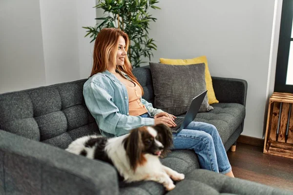 Genç Beyaz Kadın Dizüstü Bilgisayar Kullanıyor Kanepede Köpeğiyle Oturuyor — Stok fotoğraf