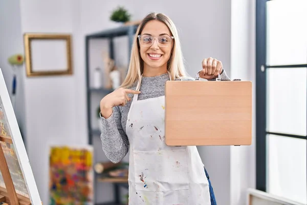 Young Blonde Painter Woman Holding Wooden Case Art Studio Pointing — Stock Photo, Image