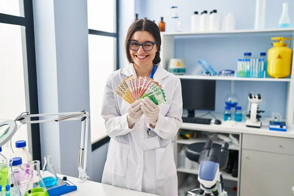Молода Іспаномовна Жінка Працює Науковій Лабораторії Тримаючи Грошові Купюри Підморгнувши — стокове фото