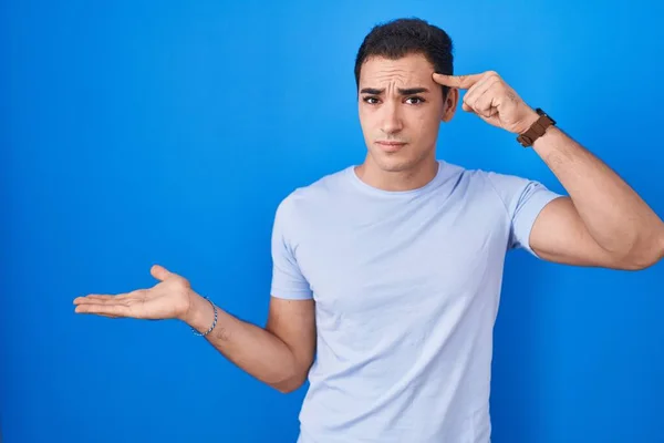 Young Hispanic Man Standing Blue Background Confused Annoyed Open Palm — Stockfoto