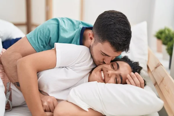 Young Hispanic Couple Lying Bed Hugging Each Other Kissing Bedroom — Stok fotoğraf