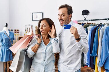 Alışveriş torbaları ve kredi kartı tutan orta yaşlı İspanyol çift, dedikodu ve dedikodulara kulak misafiri oluyor. Sağırlık kavramı. 