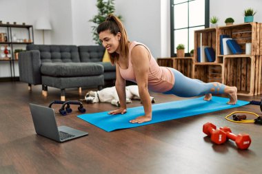 Evde karın kası egzersizi dersi alan kendine güvenen genç bir kadın.