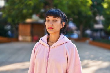 Rahat bir ifadeyle parkta nefes alan genç bir kadın.