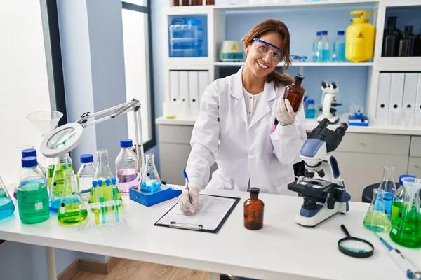 Jovem Latina Vestindo Uniforme Cientista Escrevendo Área Transferência Laboratório — Fotografia de Stock