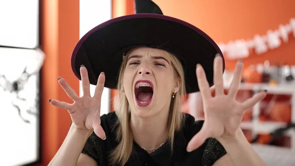 Young Blonde Woman Wearing Witch Costume Doing Scare Gesture Home — ストック写真