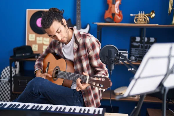 若いヒスパニック系の男のミュージシャンが音楽スタジオでクラシックギターを演奏 — ストック写真