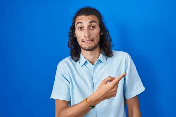 Young Hispanic Man Standing Blue Background Pointing Aside Worried Nervous — Stockfoto