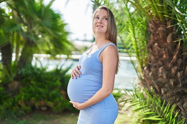 Junge Schwangere Frau Lächelt Selbstbewusst Und Berührt Bauch Park — Stockfoto