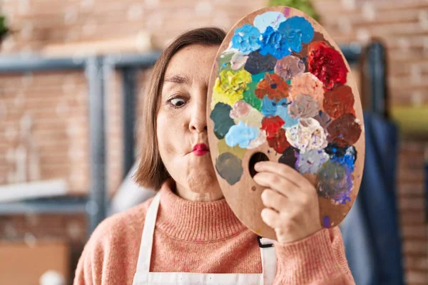 Mujer Hispana Mediana Edad Sosteniendo Paleta Pintores Cerca Cara Haciendo —  Fotos de Stock