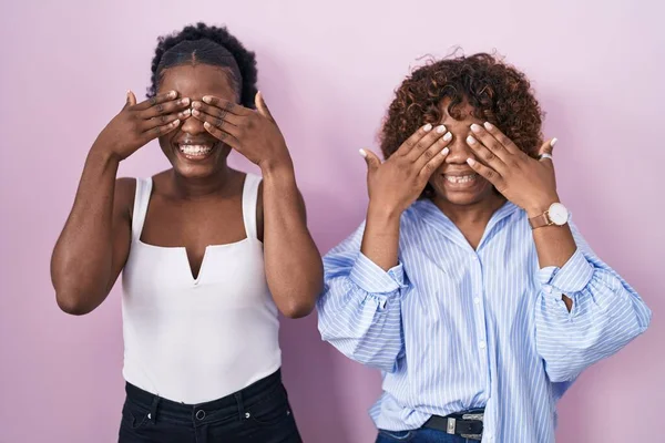 Duas Mulheres Africanas Sobre Fundo Rosa Cobrindo Olhos Com Mãos — Fotografia de Stock