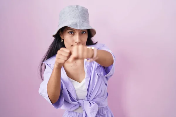 Mujer Hispana Joven Pie Sobre Fondo Rosa Usando Sombrero Puñetazo —  Fotos de Stock