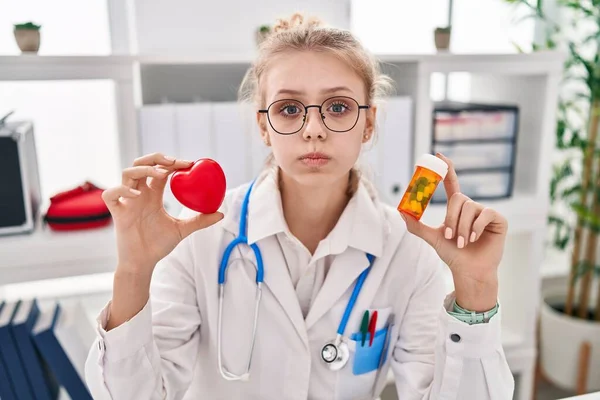 Jovem Mulher Médica Caucasiana Segurando Pílulas Bochechas Soprando Coração Com — Fotografia de Stock