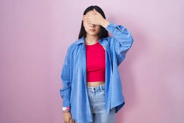 Młoda Azjatka Stojąca Nad Różowym Tłem Okrywająca Oczy Dłonią Wyglądająca — Zdjęcie stockowe