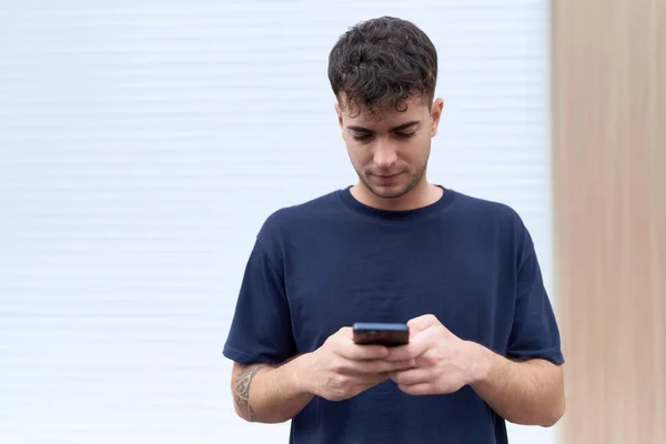 Jonge Spaanse Man Met Behulp Van Smartphone Met Serieuze Expressie — Stockfoto