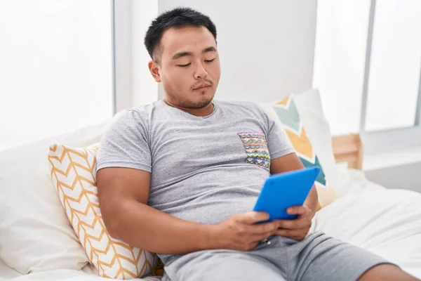 Junger Chinese Schaut Video Auf Touchpad Mit Ernstem Gesichtsausdruck Schlafzimmer — Stockfoto