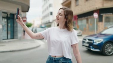Young woman smiling confident making selfie by the smartphone at street