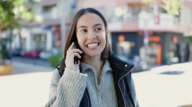 Young beautiful hispanic woman smiling confident talking on smartphone at street