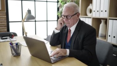 Ofiste dizüstü bilgisayarla çalışan bir iş adamı.