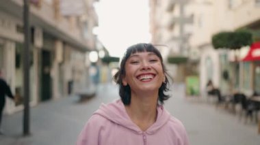 Sokakta kendine güvenen genç İspanyol kadın gülümsüyor