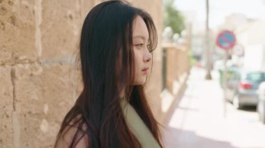 Young chinese woman smiling confident standing at street