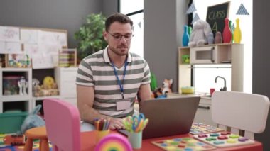 Young caucasian man on a video call working as teacher at kindergarten