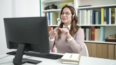 Genç, güzel İspanyol kız öğrenci kütüphane üniversitesinde not defterine video mesajı yazıyor.