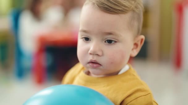Liebenswertes Blondes Kleinkind Hält Ball Mit Entspanntem Gesichtsausdruck Kindergarten — Stockvideo