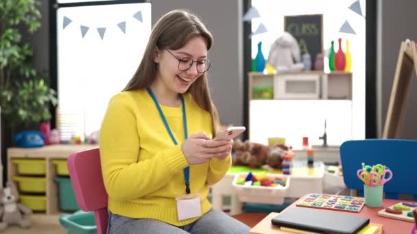Young Blonde Woman Preschool Teacher Smiling Confident Using Smartphone Kindergarten — Vídeos de Stock