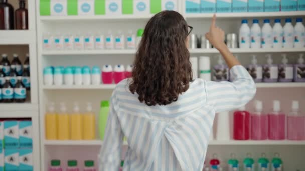薬局で棚の製品を保持する若いアフリカ系アメリカ人女性の顧客 — ストック動画