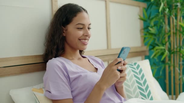 Young African American Woman Using Smartphone Sitting Bed Bedroom — Stock video
