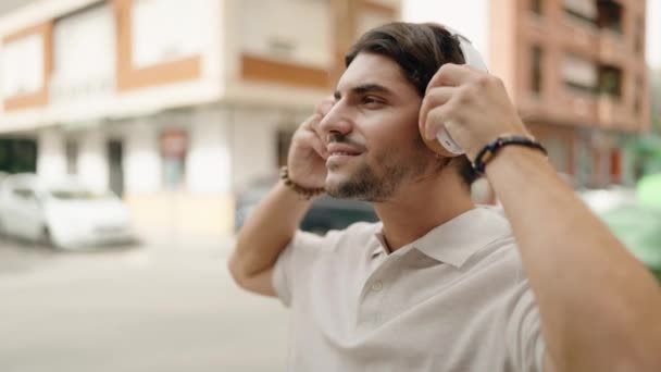 Молодий Іспаномовний Чоловік Посміхається Впевнено Слухати Музику Вулиці — стокове відео
