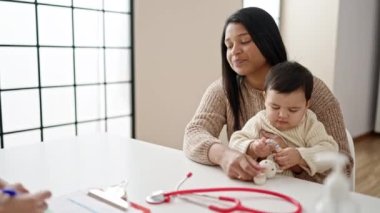 Çift ve oğul gülümseyerek klinikte kendinden emin bir şekilde el sıkışıyor