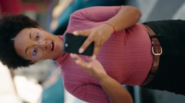 Afro-Amerikalı kadın akıllı telefon kullanıyor.