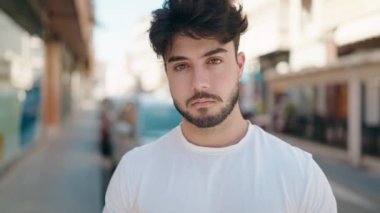 Sokakta kendinden emin gülümseyen İspanyol genç adam.