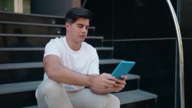 Sokakta dokunmatik ped kullanan, kendine güvenen İspanyol genç adam.