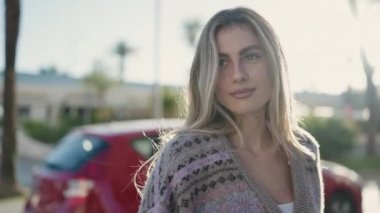 Sokakta kendine güvenen genç sarışın kadın gülümsüyor