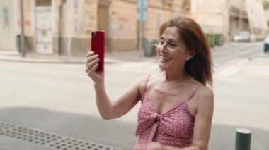 Middle age woman smiling confident having video call at street