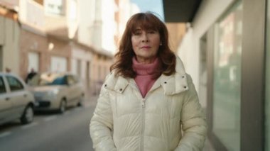 Middle age redhead woman smiling confident standing at street