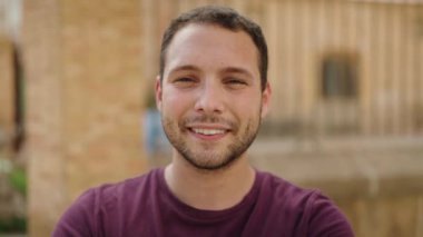 Sokakta kendine güvenen genç adam gülümsüyor