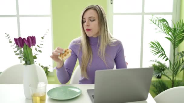 Genç Sarışın Kadın Kahvaltısını Evde Dizüstü Bilgisayar Kullanarak Yapıyor — Stok video