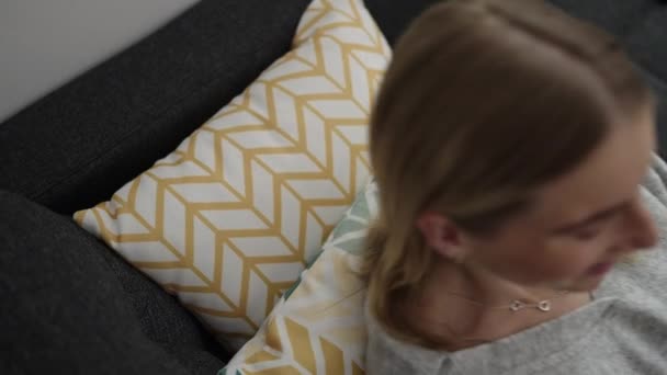 Young Blonde Woman Using Smartphone Lying Sofa Home — Vídeos de Stock