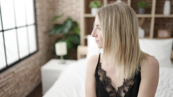 Junge Blonde Frau Sitzt Auf Bett Und Sieht Sexy Schlafzimmer — Stockvideo