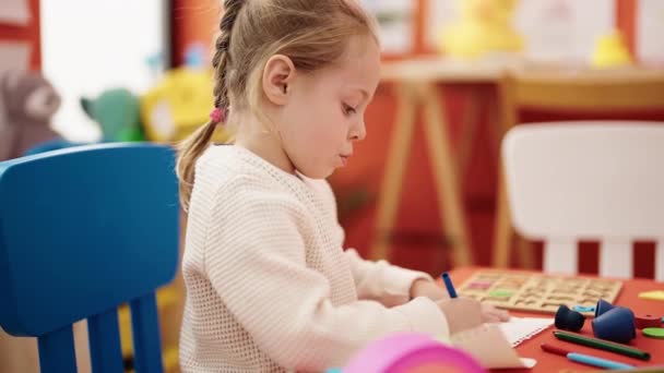 Adorable Blonde Girl Preschool Student Sitting Table Drawing Paper Kindergarten — Stockvideo