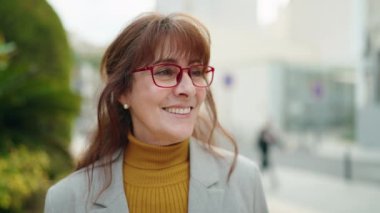 Middle age woman business executive standing with arms crossed gesture at park