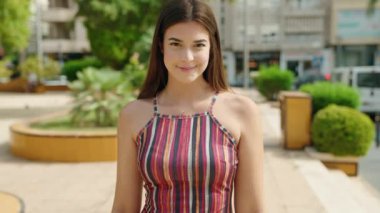 Genç, güzel İspanyol kadın gülümsüyor. Kendine güveniyor. Parkta imzasını atıyor.