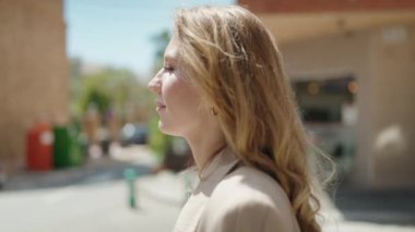 Sokakta kendine güvenen genç sarışın kadın gülümsüyor