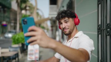 Young arab man smiling confident having video call at street