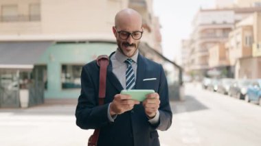 Genç İspanyol yönetici gülerek sokakta video oyunu oynuyor.