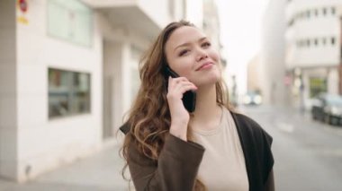 Genç İspanyol kadın gülümsüyor. Kendine güveniyor. Akıllı telefondan konuşuyor.